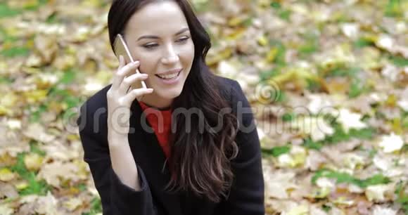女人在草地上打电话视频的预览图