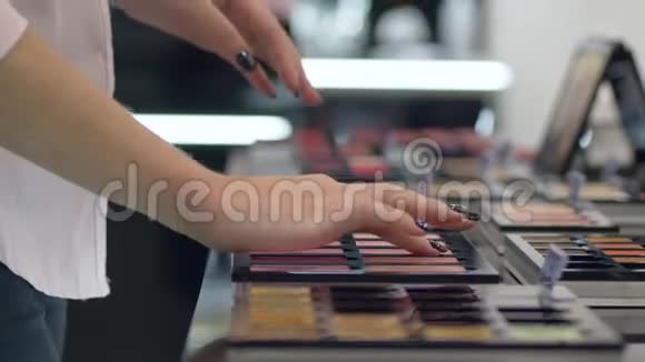 时尚购物者女孩选择新色调的胭脂粉底妆和在化妆品店手头测试视频的预览图
