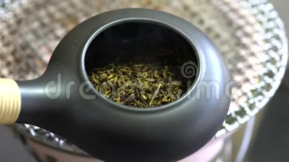 在Earthen炭炉上用陶器烤盘烤绿茶烤绿茶视频的预览图