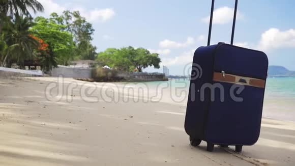蓝色的小手提箱站在美丽的大海的岸边期待已久的休闲理念旅游休闲理念视频的预览图