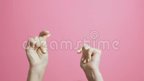 一个年轻女人的手在粉红色的画室背景上欢快地拍打着节拍视频的预览图