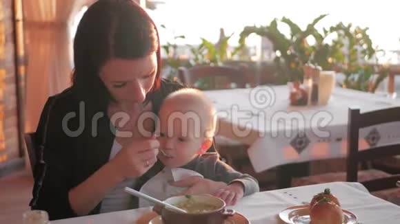 小男孩和妈妈在咖啡馆宝宝在餐馆小男孩有一块面包视频的预览图