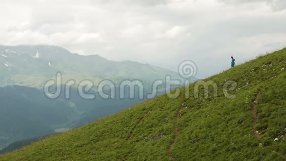 穿蓝色衣服的女孩从高山上下来视频的预览图