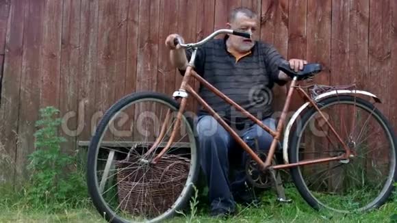 老人对旧的生锈自行车和古老的柳条篮子不高兴视频的预览图