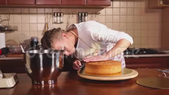 女人在厨房的旋转板上切蛋糕的烘焙预制件视频的预览图