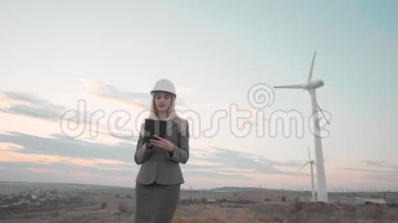 风车和背景中的物体戴着头盔的商务女士戴着数码风车的背景视频的预览图