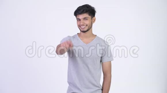 年轻快乐的留胡子的印度男人指着相机视频的预览图
