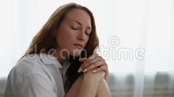 一个穿着白色衬衫的悲伤女人在家特写视频的预览图