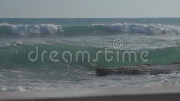 巨大的海浪在海滩上翻滚蓝天慢动作视频的预览图