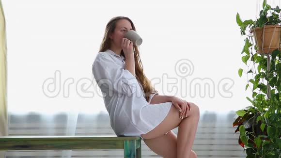 穿着白色衬衫女人在家喝咖啡视频的预览图