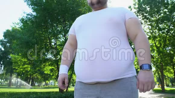 慢跑后用智能手表监测心跳的肥胖男子医疗保健应用视频的预览图