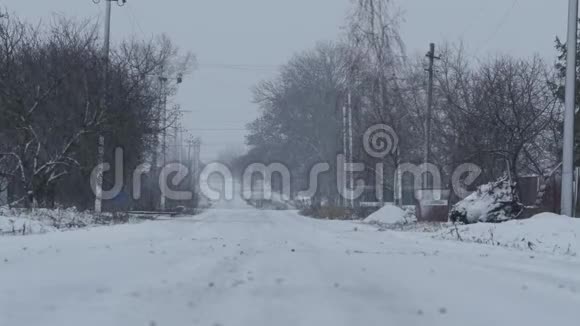 雪天期间村内空街混凝土柱子和人走视频的预览图