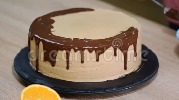厨师挤压奶油巧克力蛋糕上的糖霜白色蛋糕上覆盖着巧克力和奶油巧克力蛋糕装饰视频的预览图