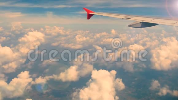 4K镜头乘飞机旅行透过飞机窗户的鸟瞰日落或日出时间有镜头耀斑的机翼飞机视频的预览图