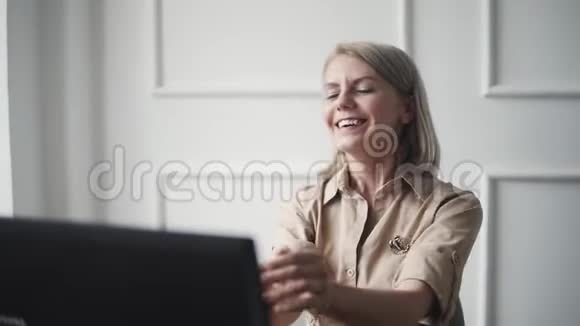 年轻快乐的女人在笔记本电脑前工作笑着时尚女孩在网上购物时很开心视频的预览图