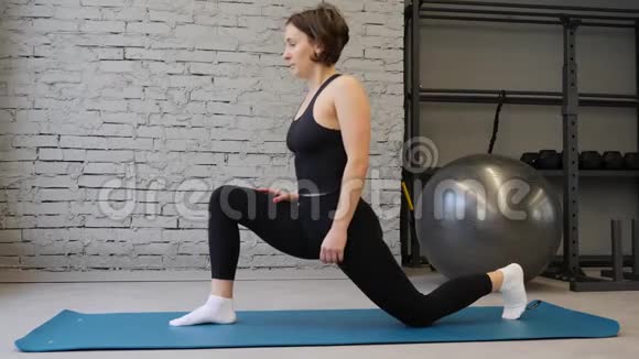 瑜伽垫年轻的运动女性伸展臀部腿筋肌肉腿部肌肉在健身房伸展运动视频的预览图