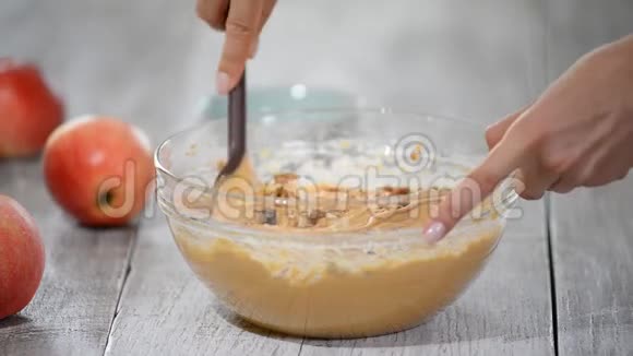 厨房里的厨师用抹刀混合在玻璃碗里做焦糖苹果蛋糕视频的预览图