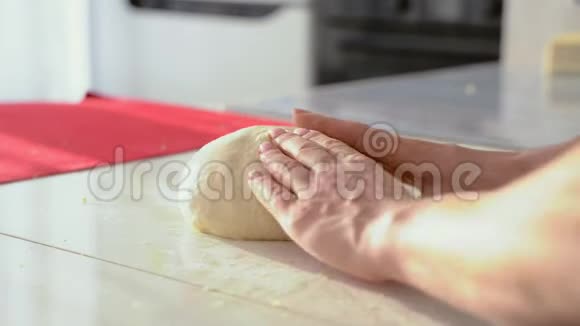 面包师在桌子上用面粉揉面把有面团的女性手收起来视频的预览图