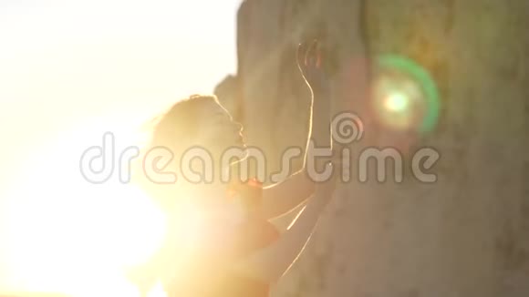在岩石和阳光的背景下女人轻盈的轮廓视频的预览图