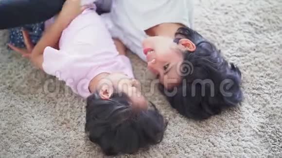 快乐的女人和她的女儿在地毯上开玩笑视频的预览图