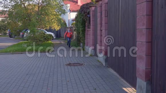 一个十岁的学生从学校跑来背着一个背包微笑着慢动作视频的预览图