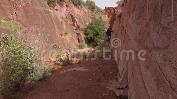 老妇人漫步到红色大理石沉积的峡谷中视频的预览图