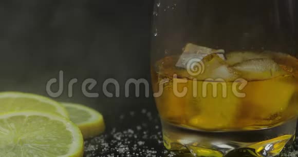 威士忌加冰块在酒杯里黑色背景一杯朗姆酒视频的预览图
