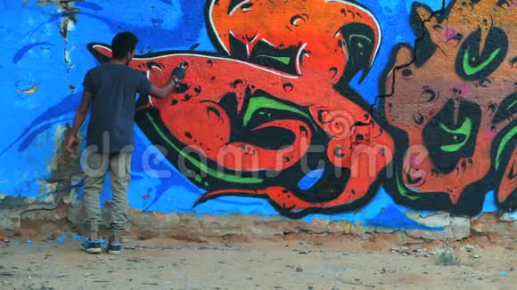 创意艺术少年画彩色抽象装饰涂鸦在街墙与气溶胶喷雾慢动作视频的预览图
