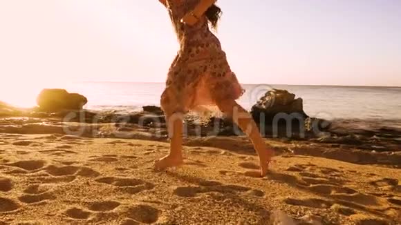 年轻女孩赤脚在阳光明媚的海滩上奔跑视频的预览图