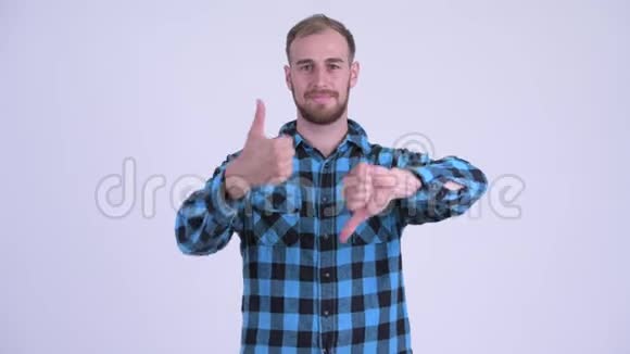 愚蠢的留着胡子的嬉皮士男人在拇指向上和拇指向下之间做出选择视频的预览图