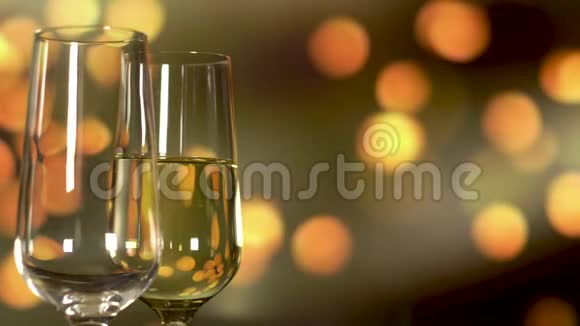在金色假日闪烁的背景下将起泡香槟倒入玻璃中视频的预览图