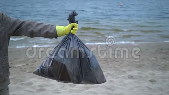 义工手拿沙滩垃圾袋视频的预览图