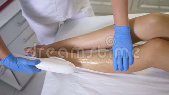 美容方面的独特技术美容师在治疗室对病人的双脚进行激光脱毛视频的预览图