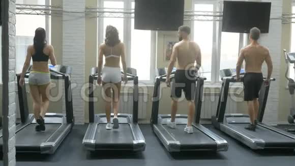 健身女孩和男人在健身房跑步机上跑步年轻健康的人在跑步机上跑步健身和健康的生活方式视频的预览图
