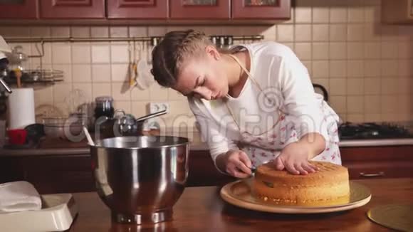 一个做厨师的女人用刀子切新鲜出炉的蛋糕视频的预览图