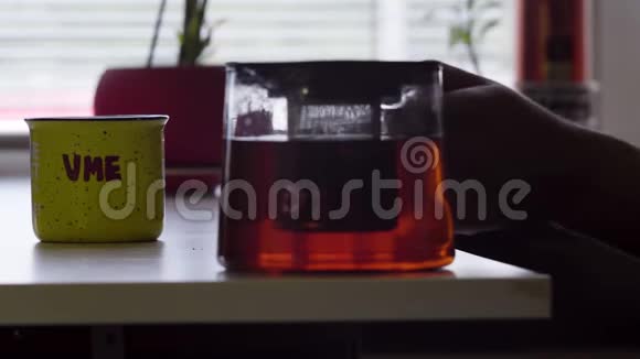 镜头显示桌子上有大杯子和玻璃茶壶全泡茶饮料视频的预览图