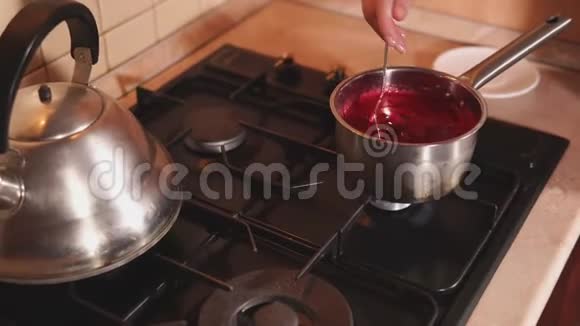 女人正在锅里搅拌浆果汁视频的预览图