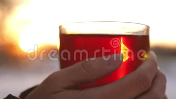 女孩正拿着一杯热茶在夕阳下徘徊视频的预览图