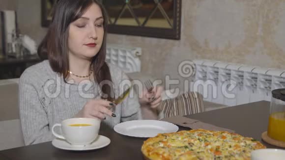 披萨饼年轻女子拿着一片带餐具的披萨视频的预览图