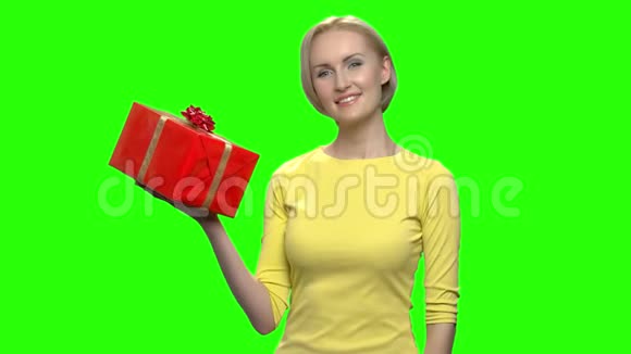 漂亮的成熟女人穿着黄色毛衣手拿红色礼盒视频的预览图