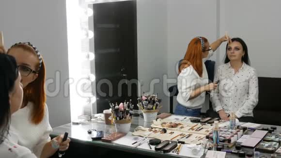 专业的眼妆化妆师在美容院用特殊的刷子给年轻女子化妆视频的预览图