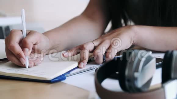 特写女性手拿笔写笔记视频的预览图