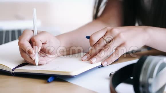 特写女性手拿笔写笔记视频的预览图