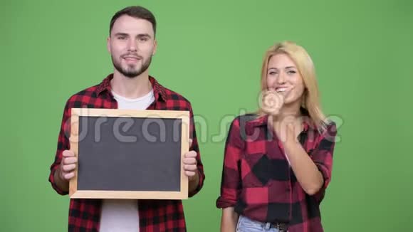 年轻夫妇举着黑板一起竖起大拇指视频的预览图
