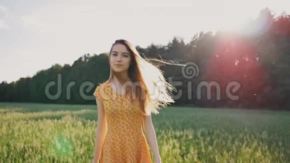 一个穿着裙子的漂亮年轻的俄罗斯女孩正快速地穿过麦田在森林附近长发飞舞视频的预览图