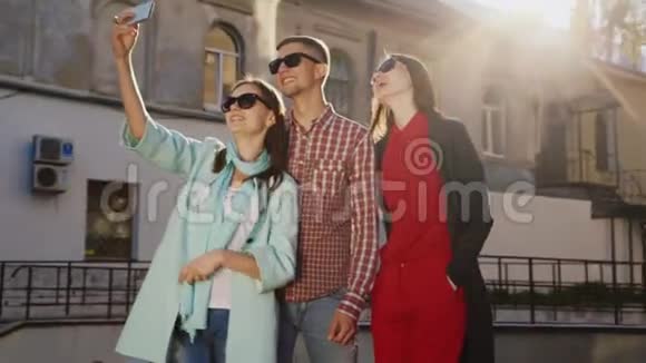 朋友两个女人和一个男人在阳光下自拍在一座古老建筑的背景下视频的预览图
