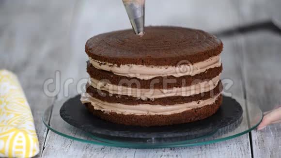 奶油被挤在巧克力蛋糕上把奶油挤在蛋糕上视频的预览图