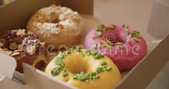带外卖的盒子里有美味甜蜜五颜六色的甜甜圈视频的预览图