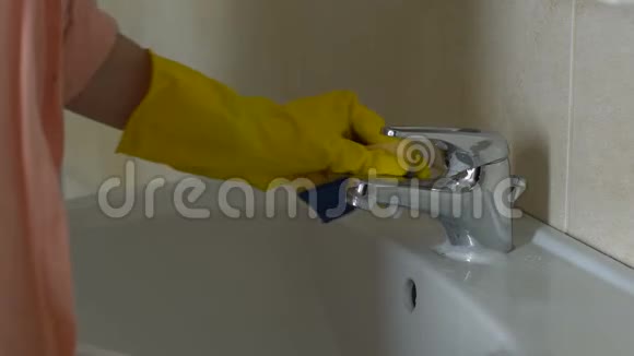 妇女彻底清洗水龙头和脸盆日常房屋清洁卫生视频的预览图