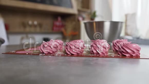 女人把粉红色的棉花糖放在厨房的桌子上视频的预览图